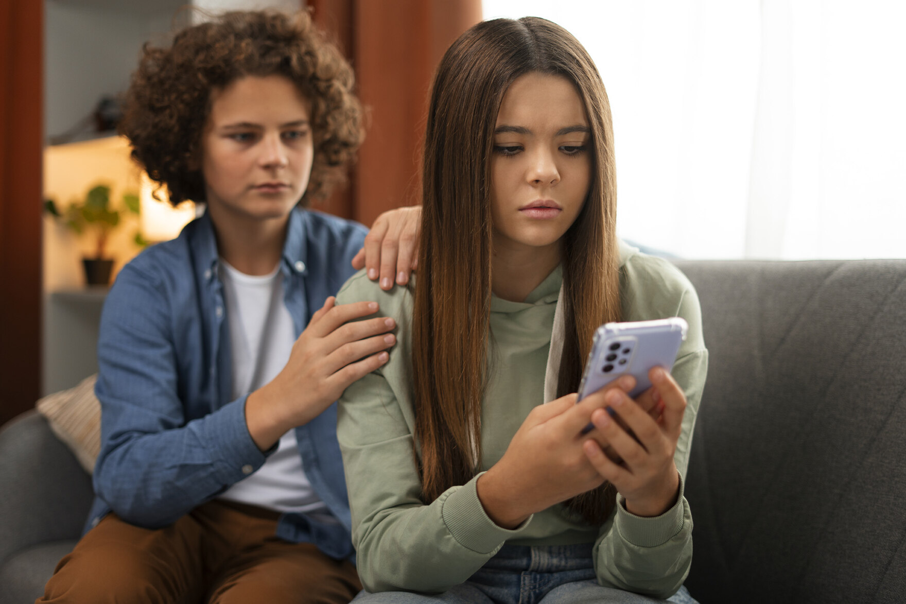 Traurige Jugendliche am Smartphone
