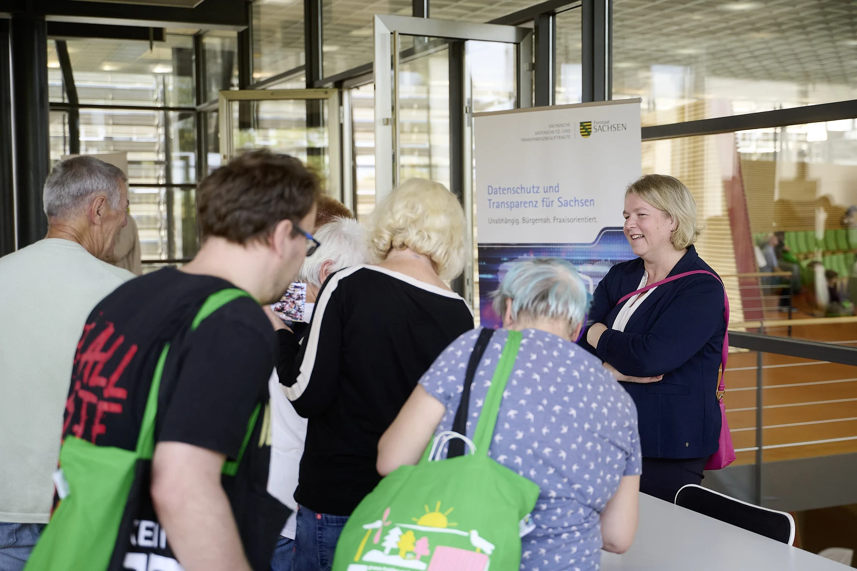 Dr. Juliane Hundert und mehrere Besucherinnen und Besucher am Stand im Sächsischen Landtag