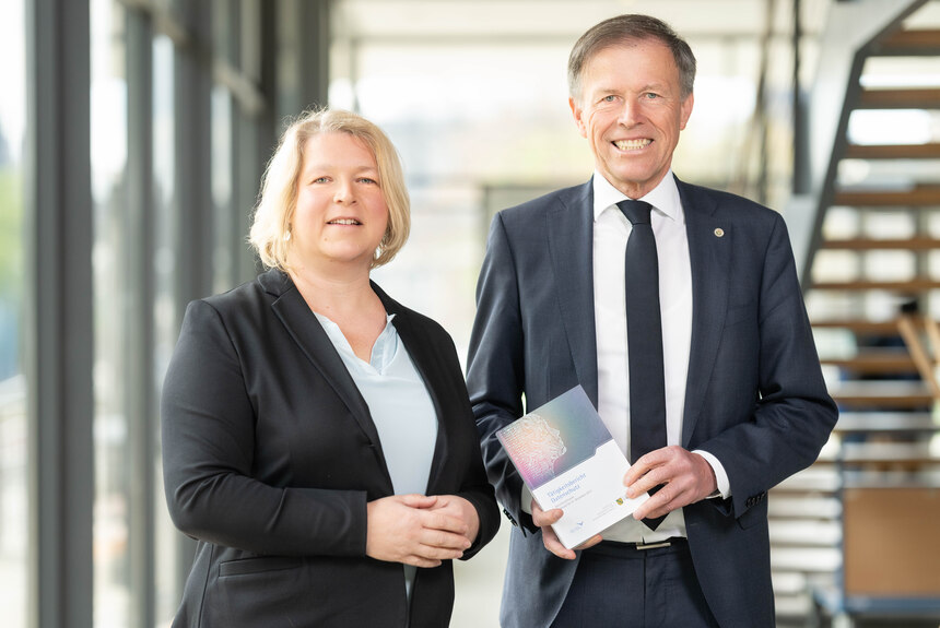 Dr. Juliane Hundert steht neben Landtagspräsident Dr. Matthias Rößler, den den Tätigkeitsbericht Datenschutz 2023 hält.