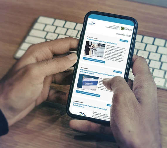 In zwei Händen gehaltenes Smartphone auf dem der SDTB-Newsletter angezeigt wird