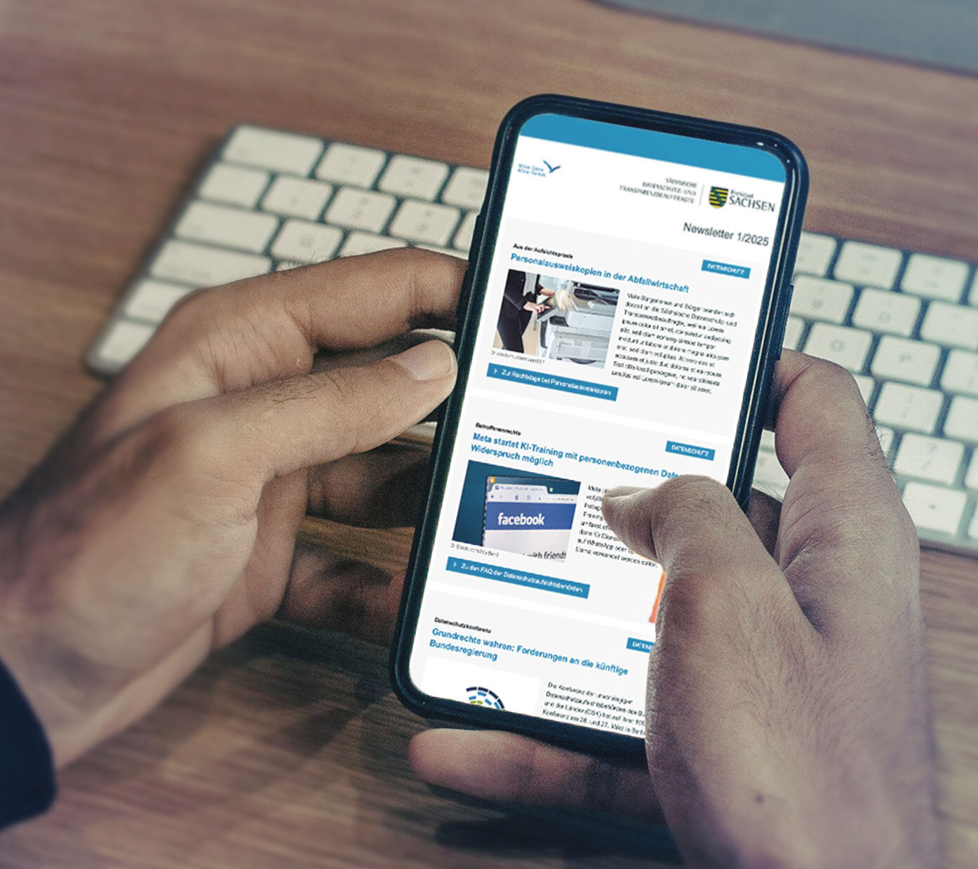 In zwei Händen gehaltenes Smartphone auf dem der SDTB-Newsletter angezeigt wird